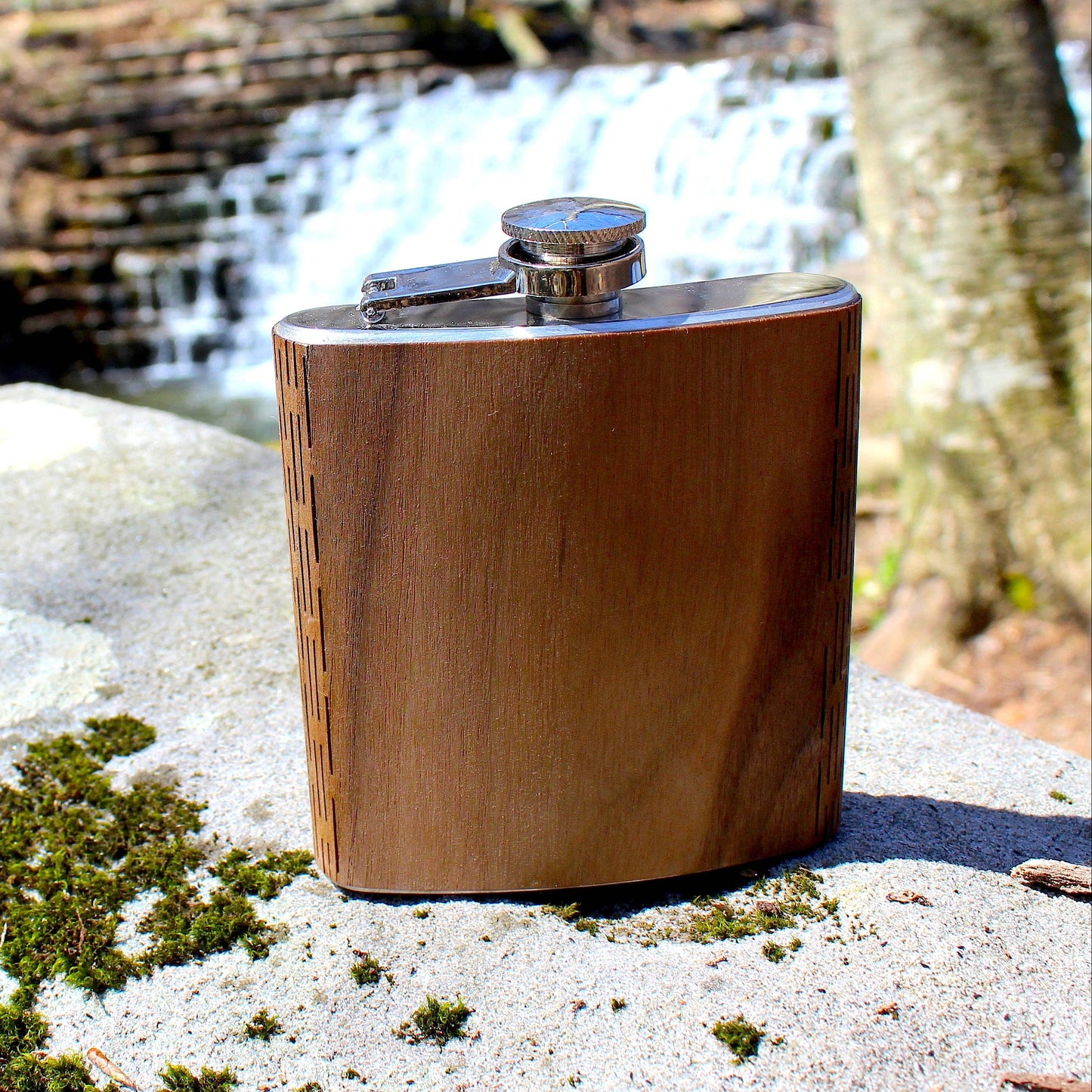 Wooden hip flask on a rock with a natural background