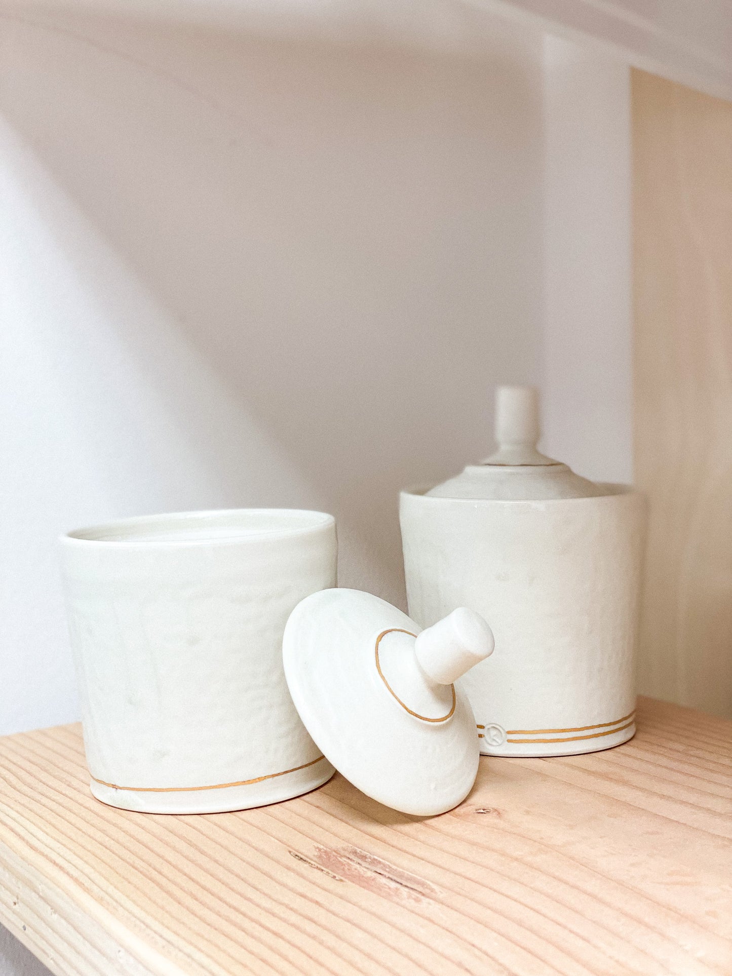 ceramic container jars with lids. handmade. on wooden surface