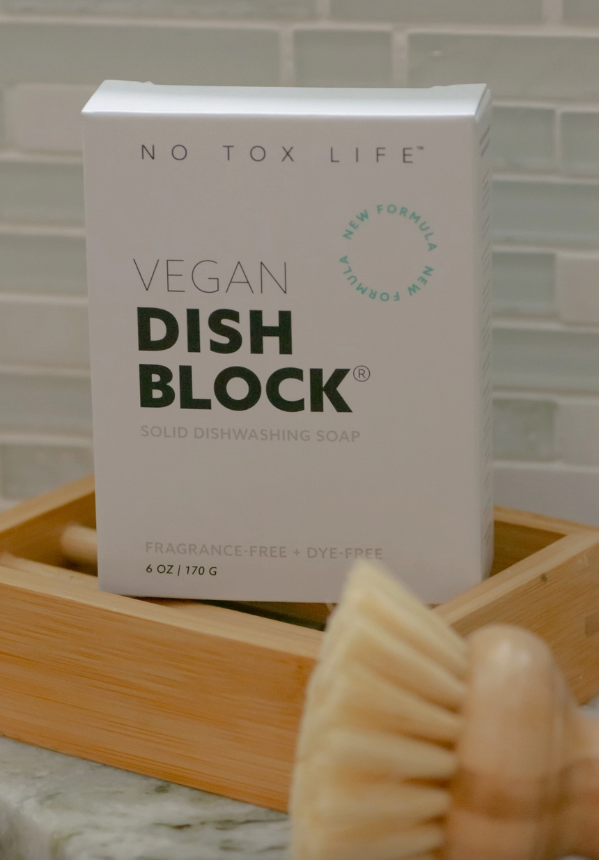 Vegan dish block packaging with a wooden dish brush on a marble surface