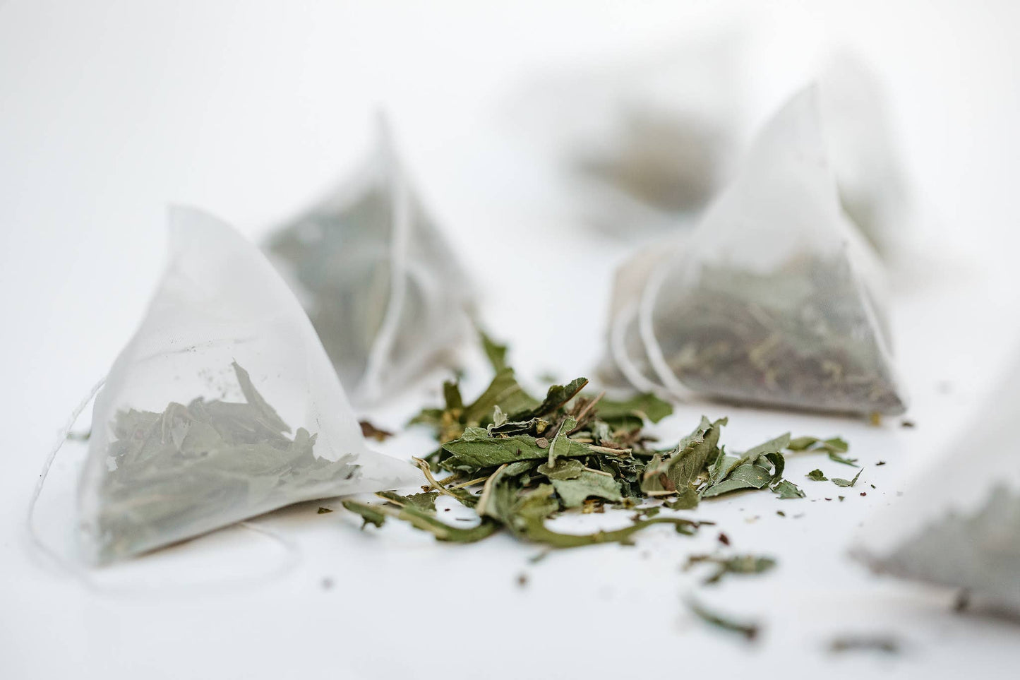 Tea bags with loose tea leaves on a white background