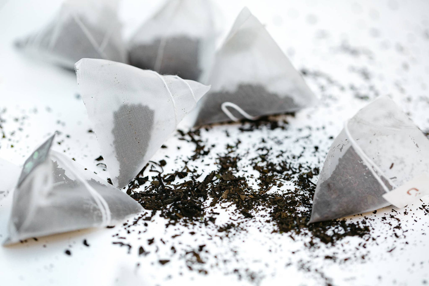 Tea bags with loose tea leaves on a white background