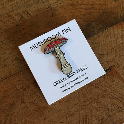 Mushroom pin on a card with 'Green Bird Press' branding on a wooden surface