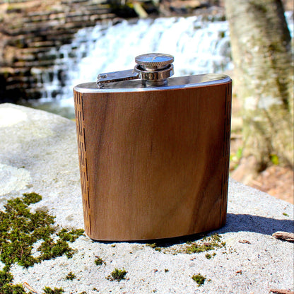 Wooden hip flask on a rock with a natural background