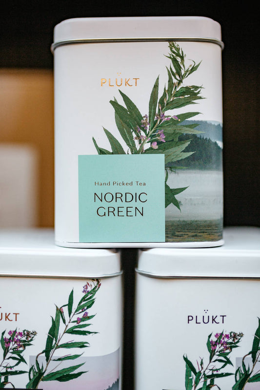 Tea canisters with 'Nordic Green' label and nature-themed design