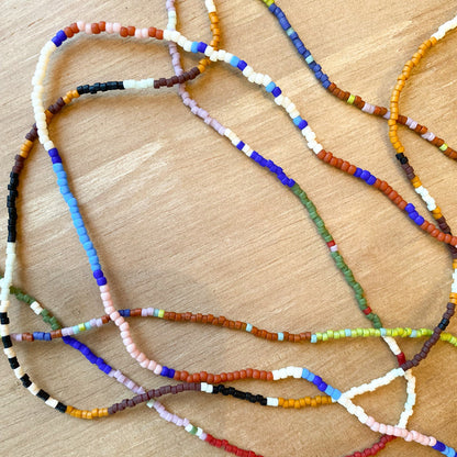 Colorful beaded necklaces on a wooden surface
