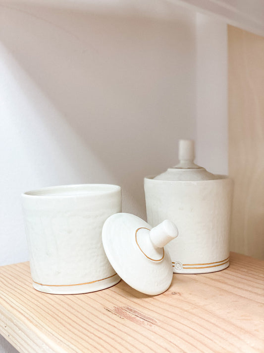 ceramic container jars with lids. handmade. on wooden surface