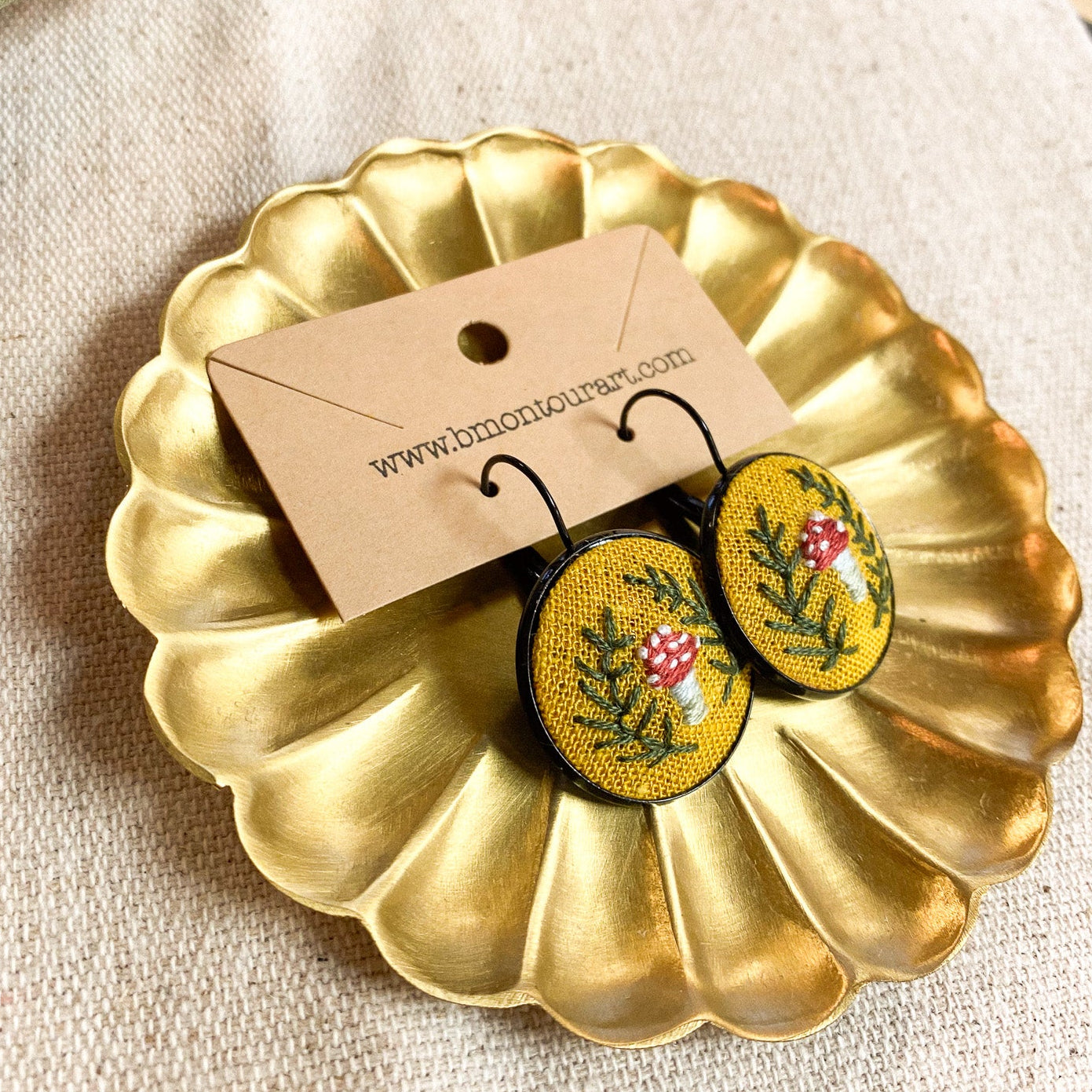 Floral earrings on a decorative gold plate with a beige background