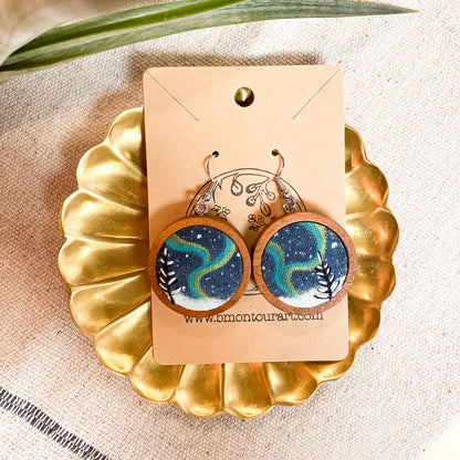 Wooden earrings with a starry night design on a gold stand with a beige background