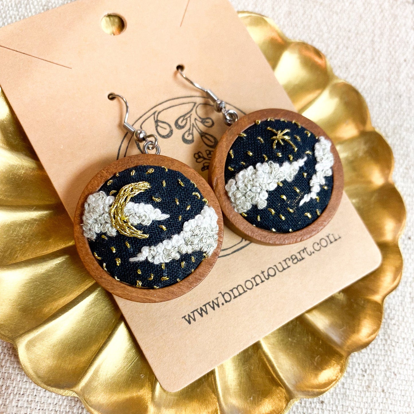 Wooden earrings with celestial design on a gold stand and beige card.