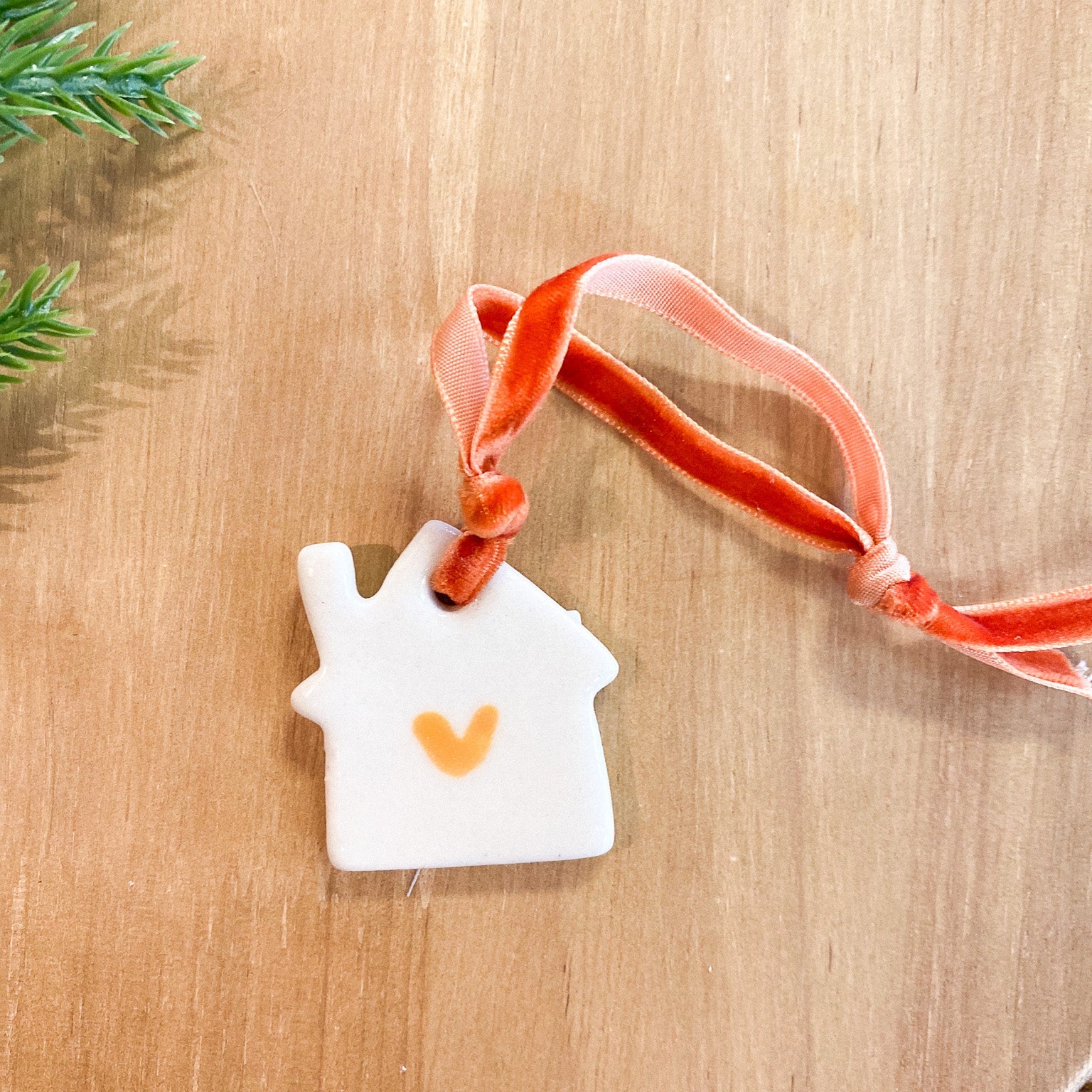 Decorative house ornament with a heart on a wooden surface