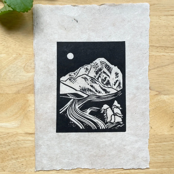 Black and white mountain illustration on a textured paper with green leaves in the corner.