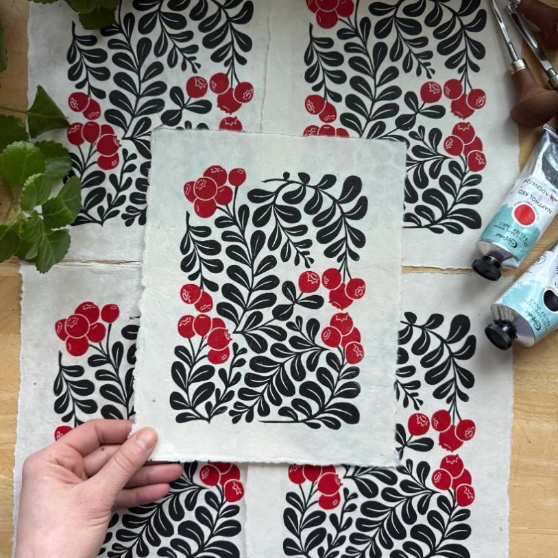 Fabric with black and red floral pattern on a wooden surface