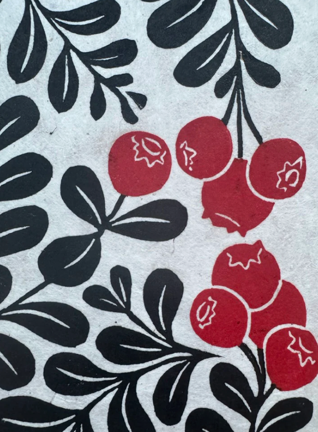 Pattern of red berries and black leaves on a textured background