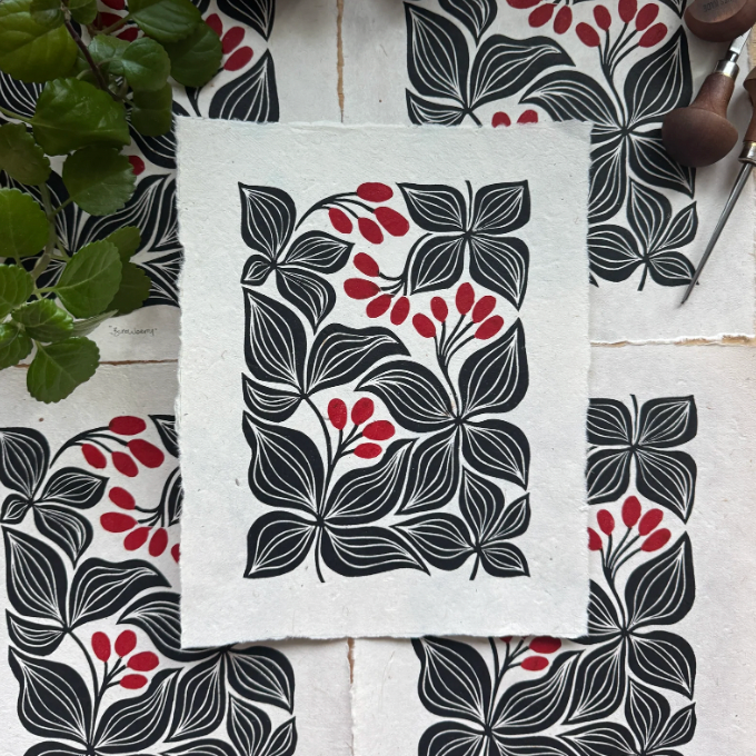 Floral patterned fabric with black, red, and gray design on a white surface.