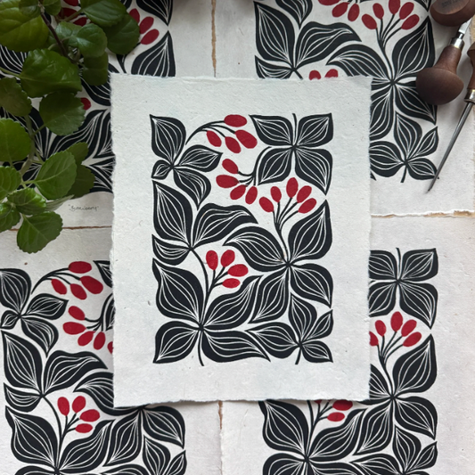 Floral patterned fabric with black, red, and gray design on a white surface.